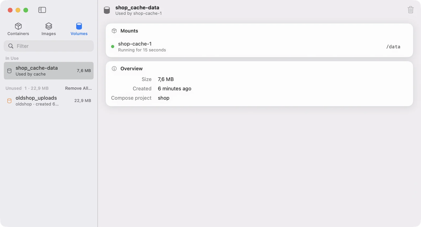 The Volumes tab: a volume in use by the cache container, mounted at /data, and an unused volume left by an old Compose project